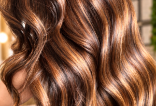 Glänzendes, welliges braunes Haar mit warmen Karamell-Highlights und natürlichen Balayage-Strähnen bei Betty Beauty.